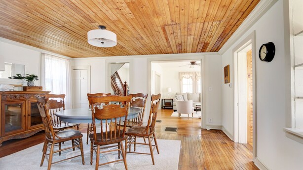 A dining area with a wooden ceiling, a round table, and matching chairs. - Charming 3-bedroom farmhouse with AC, WiFi,  5 minutes to Sea Isle Beaches! (Dennis)