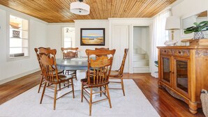 A dining area with a wooden ceiling, a round table, and four wooden chairs. - Charming 3-bedroom farmhouse with AC, WiFi,  5 minutes to Sea Isle Beaches! (Dennis)