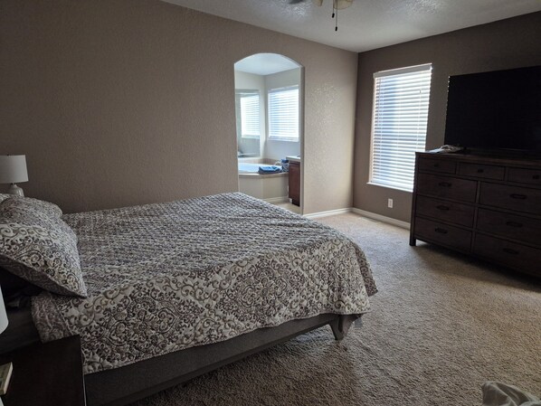 A bedroom with a bed, dresser, and a television on a dresser. - Spacious 4-bedroom house with AC, WiFi in wonderful Golden Shores (Golden Shores)