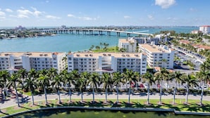 Un hotel costero con varias construcciones, un puerto deportivo y un puente al fondo.