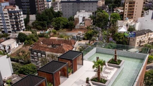 A rooftop pool area with lounge chairs and a small garden. - Charming 1-bedroom apartment with AC, WiFi in peaceful Bela Vista Porto Alegre (Rio Branco Porto Alegre)