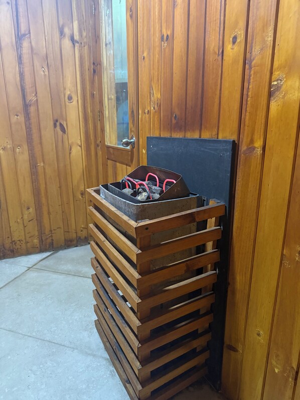 A wooden bench with a metal frame and a stack of wooden planks.