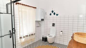 Un baño con inodoro, ducha y lavamanos.