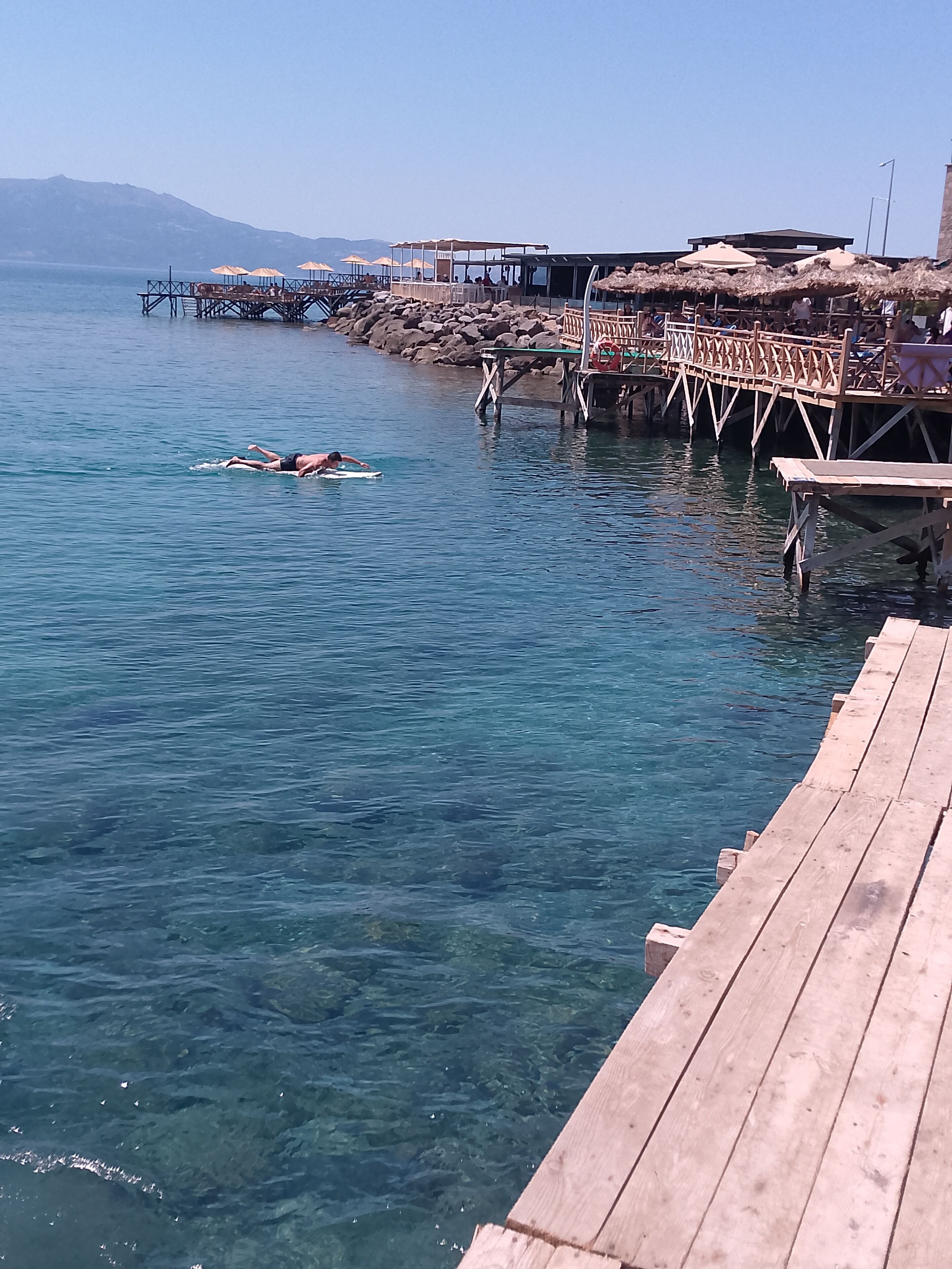 Un muelle de madera se adentra en aguas tranquilas y cristalinas.
