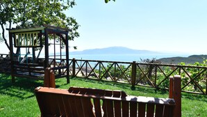 A wooden bench with a view of a mountain and the sea. - Assos Assinos (Behram)
