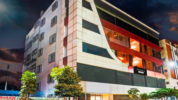 Ein mehrstöckiges Hotel mit modernem Design, das eine auffällige rote und weiße Fassade und große Fenster aufweist.