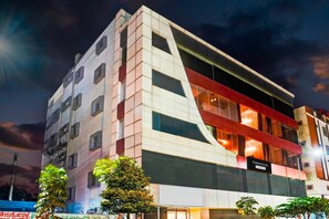 A multi-story hotel with a modern design, featuring a prominent red and white facade and large windows. - Super Collection O Singasandra Hosa Road (Bengaluru)