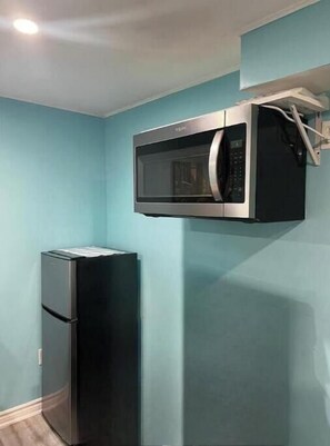 Efficient kitchen with microwave and refrigerator.