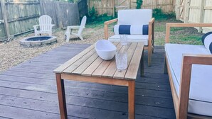 A wooden deck with outdoor furniture including a table, chairs, and a sofa. - Spacious Historic home near 12 South with easy access to local attractions (Nashville)