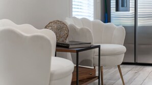 A modern living room with white chairs, a wooden coffee table, and a decorative sphere. - Comfortable group stay walkable to Vanderbilt Stadium (Nashville)