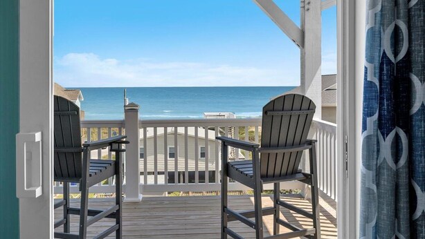 A balcony with two Adirondack chairs overlooking a beach with a clear blue sky. - Brand New Oceanview 8bed/7.5 bath Hot Tub EV Charger (Surf City)