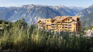 A mountain lodge with multiple balconies and a view of the surrounding mountains. - Apartment in France With Ski-in/ski-out Access (Risoul)