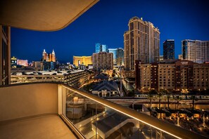 Une vue sur le paysage urbain depuis un balcon, avec des bâtiments modernes et un parking.