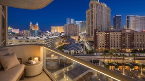 Un hotel moderno con balcón que ofrece vistas a un paisaje urbano nocturno.