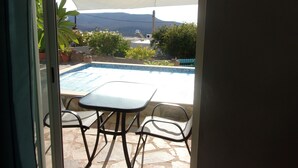 A patio with a pool, outdoor furniture, and a view of the mountains.