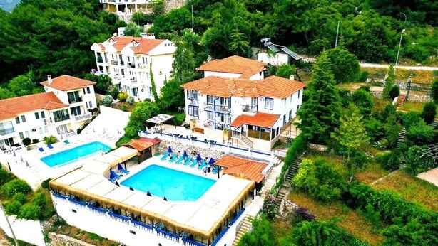 A resort with two swimming pools, multiple buildings, and lush greenery.