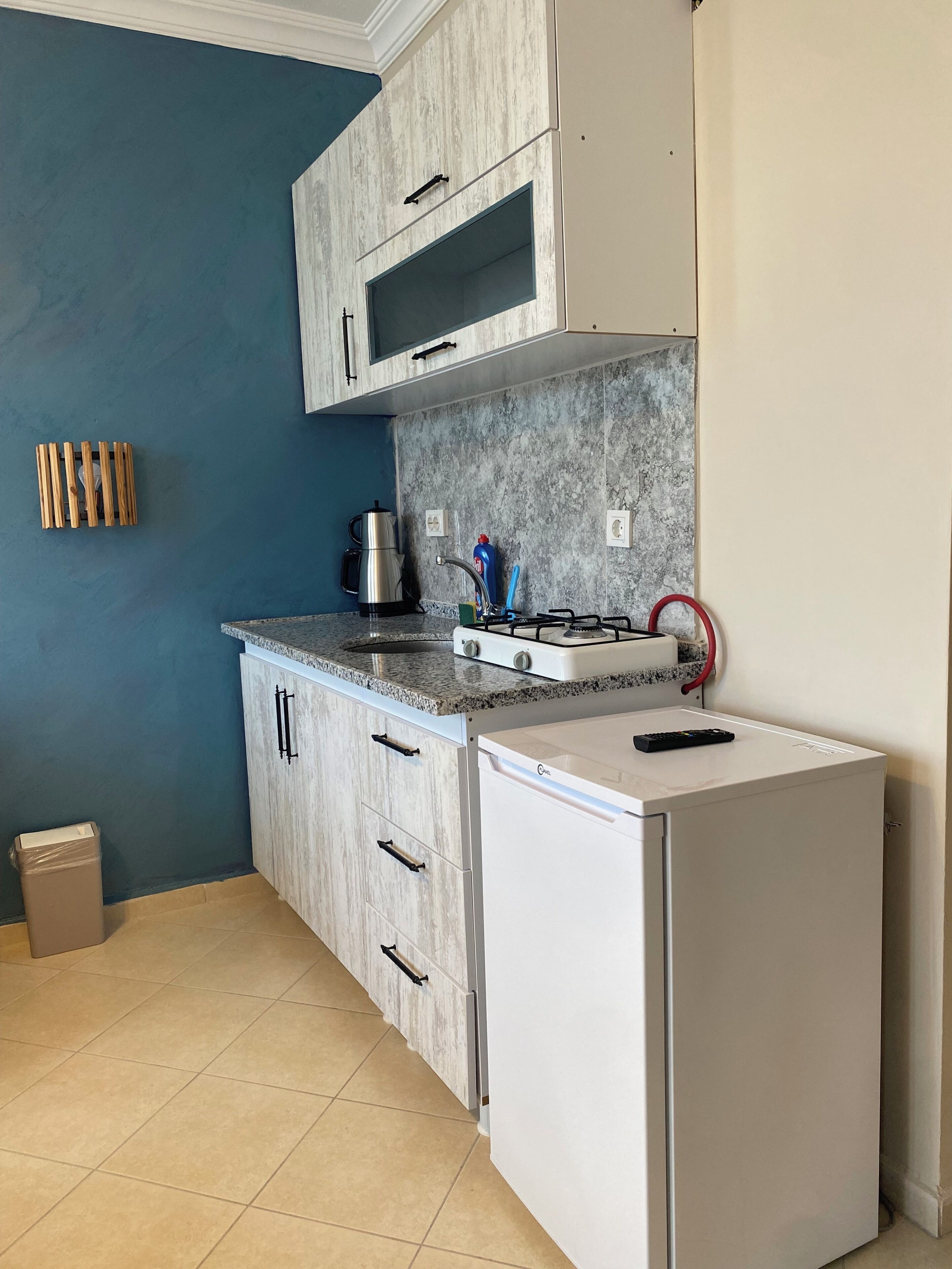 A compact kitchen with a refrigerator, stove, and cabinets.