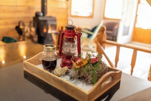 Un plateau en bois sur lequel on a posé une lanterne rouge, un bocal en verre et une petite plante.