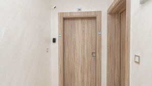 Una porta di legno con un numero 39 sopra, un campanello e un interruttore sulla parete.