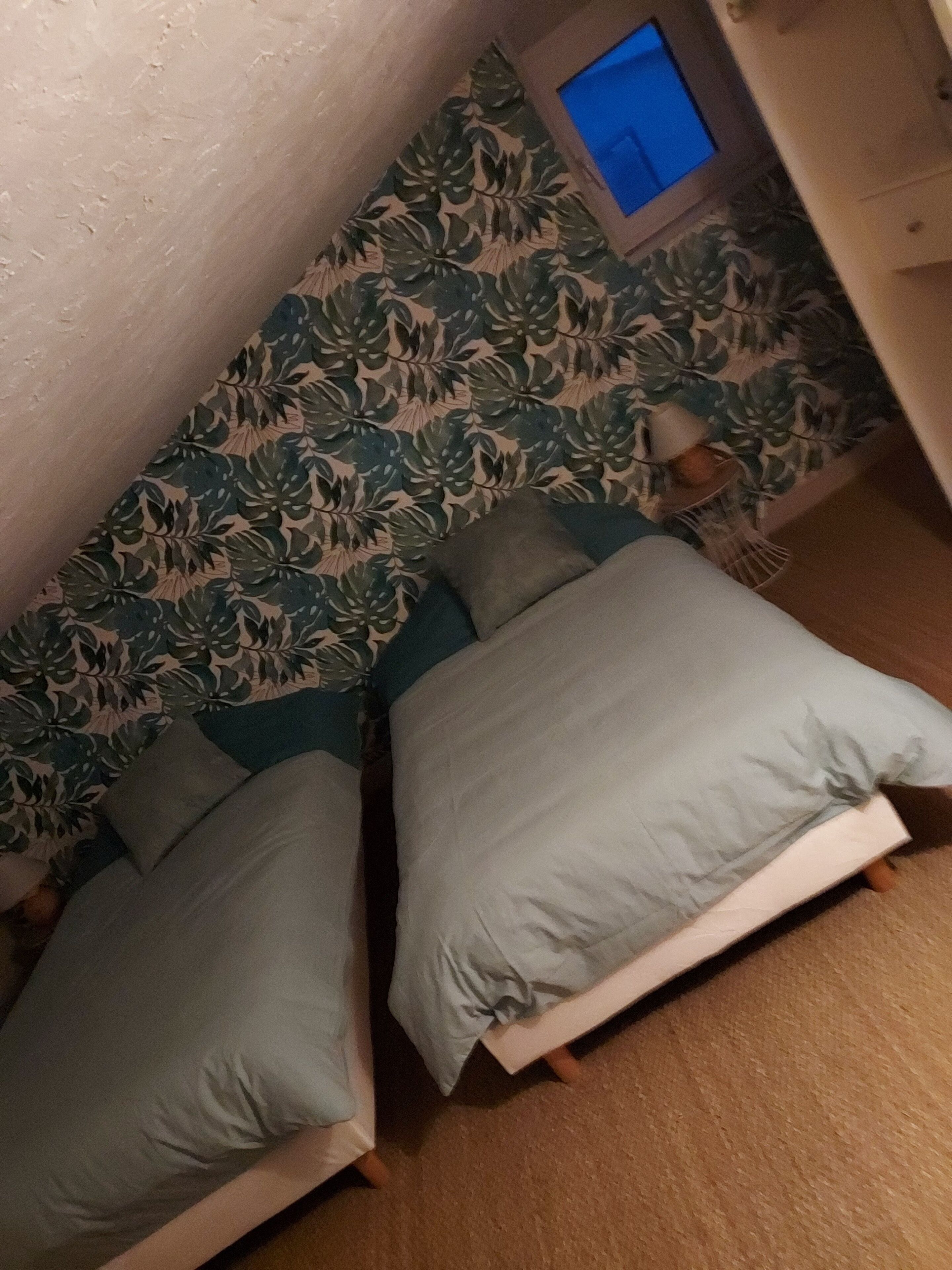 A small, cozy room with two beds, a small table, and a television.