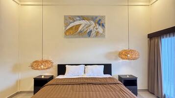Ein modernes Schlafzimmer mit einem großen Bett, zwei Nachttischen, einem Deckenventilator und einem an der Wand befestigten abstrakten Kunstwerk.