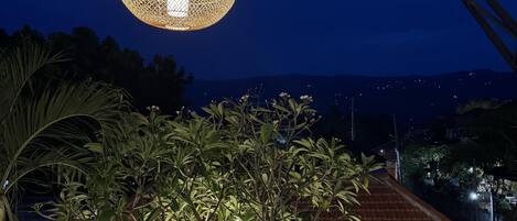 A covered outdoor area with a dining set and a hanging light fixture.