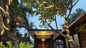 A house with a tiled entrance, a wooden door, and a porch with a bench. - Murni's House (Buleleng)
