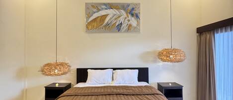 A modern bedroom with a large bed, a ceiling fan, two bedside lamps, and a decorative wall piece.