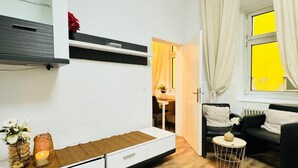 Een moderne woonkamer met een bank, een klein rond tafeltje en een bed.