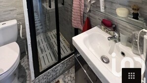 A modern bathroom with a glass-enclosed shower, a white sink, and a mirror above it.
