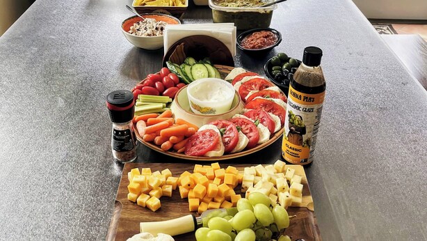 A table with a variety of food items and a bottle of sauce.