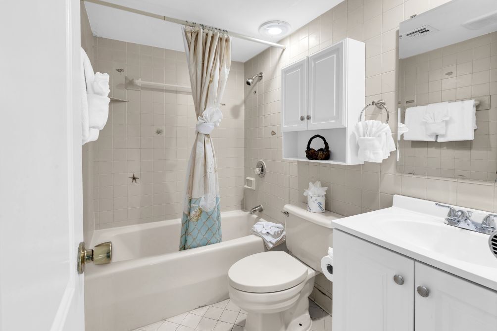 A bathroom with a bathtub, toilet, and a sink.