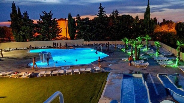 A pool area with multiple pools, lounge chairs, and palm trees. - MOBILHOME 6 PERS CAMPING 3 Stars near the sea (Lunel)