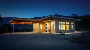A modern house with a covered porch, large windows, and a driveway. - Happy Heart House: Elegant 2-bedroom house with stunning views close to the park (Three Rivers)