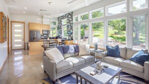 A modern kitchen with a central island, large windows, and a ceiling fan. - Happy Heart House: Elegant 2-bedroom house with stunning views close to the park (Three Rivers)