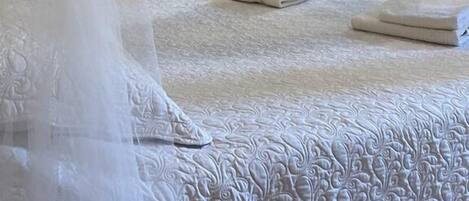 A bed with a white canopy and a neatly made bedspread.