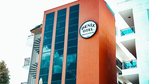 Un immeuble avec une enseigne indiquant « Hôtel Deniz » et un escalier menant à un étage supérieur.