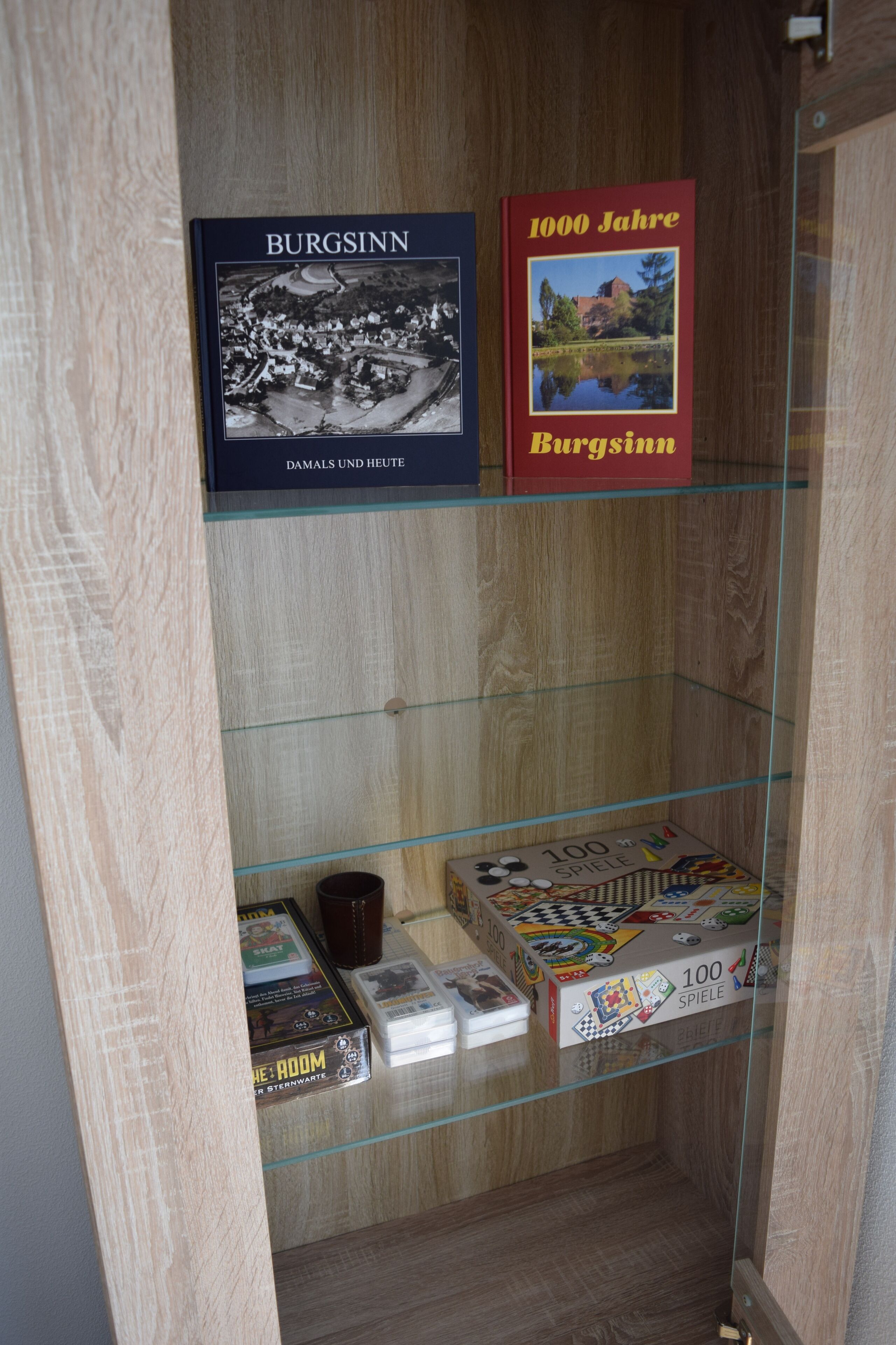 Une vitrine en verre contenant des livres et des jeux de société.