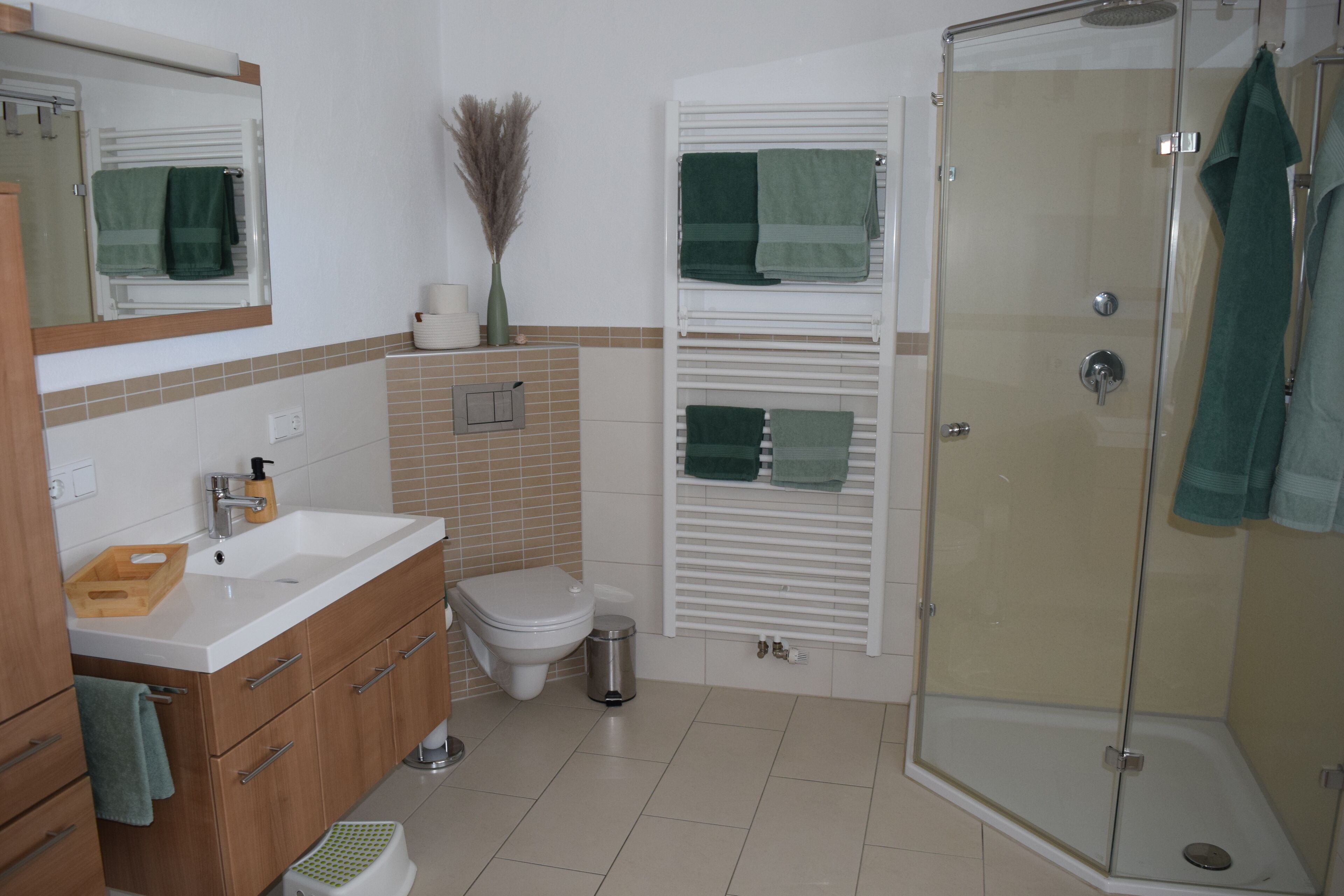 Een badkamer met douche, toilet, wastafel en badkamermeubel.
