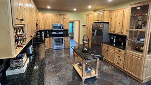 A spacious kitchen with wooden cabinets, a central island, and modern appliances.