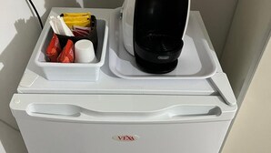 A compact refrigerator with a VEXA logo, a coffee maker, and a tray with condiments and a cup. - Lercarappart 1 (Lercara Friddi)
