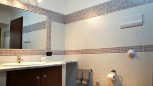 A bathroom with a large mirror, a sink, and a towel rack. - Lercarappart 1 (Lercara Friddi)