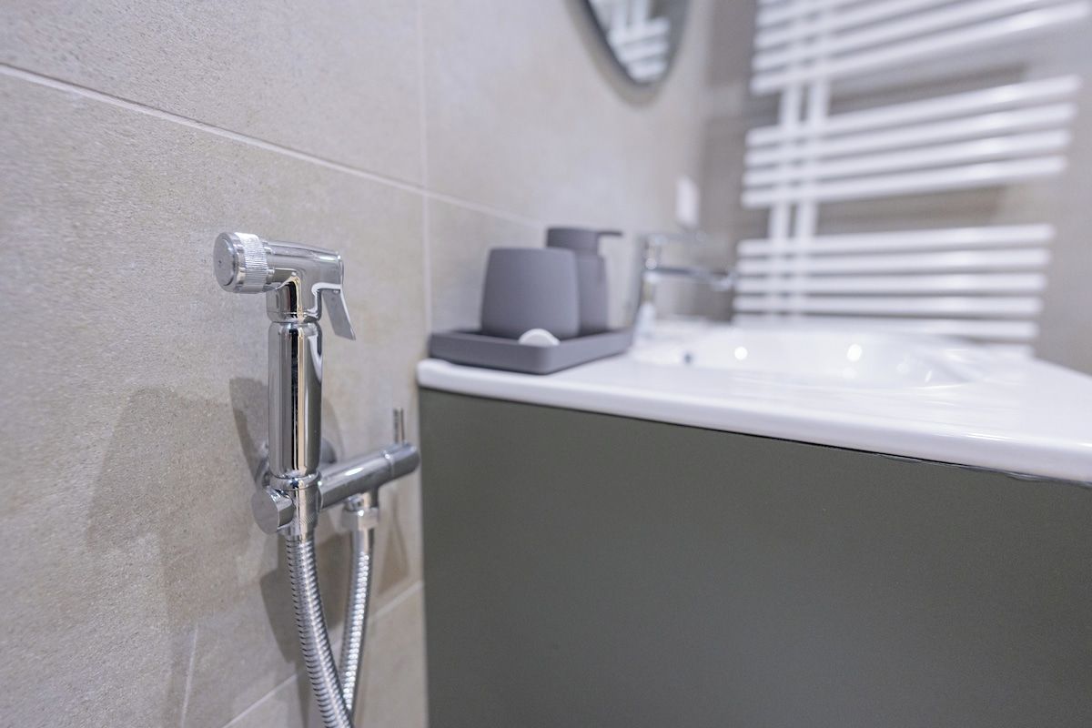 A modern bathroom with a shower, a sink, and a mirror.