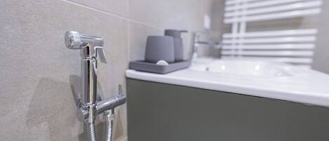 A modern bathroom with a shower, a sink, and a mirror.