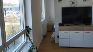 Una sala de estar moderna con un ventanal grande, un televisor de pantalla plana y un diseño minimalista.