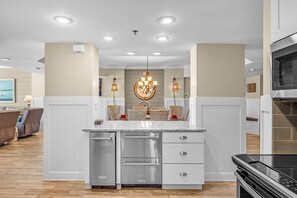 Una cocina moderna con una isla central, electrodomésticos de acero inoxidable e iluminación empotrada.