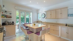 A modern kitchen with a central island, bar stools, and built-in cabinets.