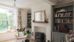 Una sala de estar acogedora con chimenea, estanterías, un sofá y una mesa de centro.