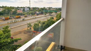 Vista desde un balcón sobre una calle con mucho tráfico, incluyendo camiones y un autobús.