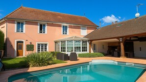 Une maison à deux étages dotée d’une piscine, d’un patio couvert et d’une véranda.